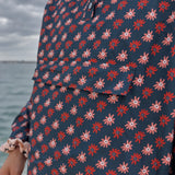Détail de la matière imperméable du poncho Paola à motifs marguerites