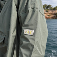Détail du tissu imperméable du poncho de pluie kaki en polyester recyclé
