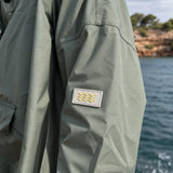 Détail du tissu imperméable du poncho de pluie kaki en polyester recyclé