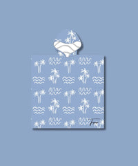 Découvrez notre poncho de plage enfant bleu avec des motifs palmiers et vagues blanches. Le lou.