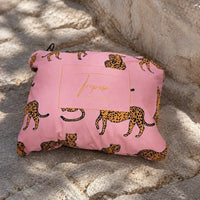 Poncho de pluie Alexie rose à motifs léopard plié dans sa pochette
