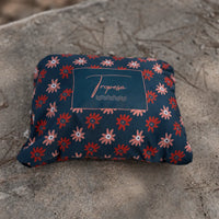 Poncho de pluie Paola bleu marine à fleurs marguerites plié dans sa pochette