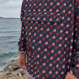 Vue de face du poncho de pluie Paola bleu marine à motifs marguerites